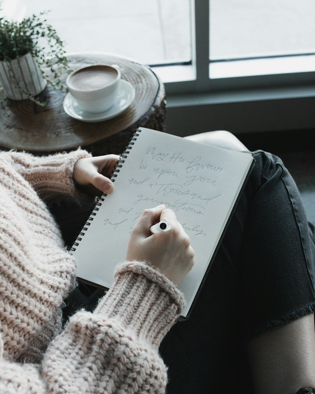 Person writing reflections in a personal journal notebook